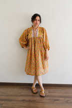 Woman wearing Evening Blush Midi Dress in Mustard Floral Handblock Sanganeri Cotton.