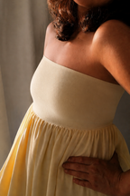 Woman wearing Golden Hour Buttercream Yellow Strapless Vacation Maxi Dress indoors.