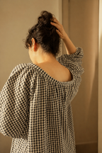 Person wearing a checkered shirt with a plain background