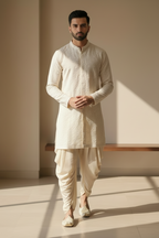 Man wearing a traditional white kurta with white pants in a minimalistic setting
