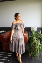 Woman in Seashell Grey Midi Dress in Mulmul Cotton Tiered silhouette, shirred waist and elasticated neckline.