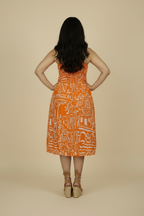 Woman in Sundown strapless midi dress in mulmul cotton with shirred bodice - back view, standing in a studio.