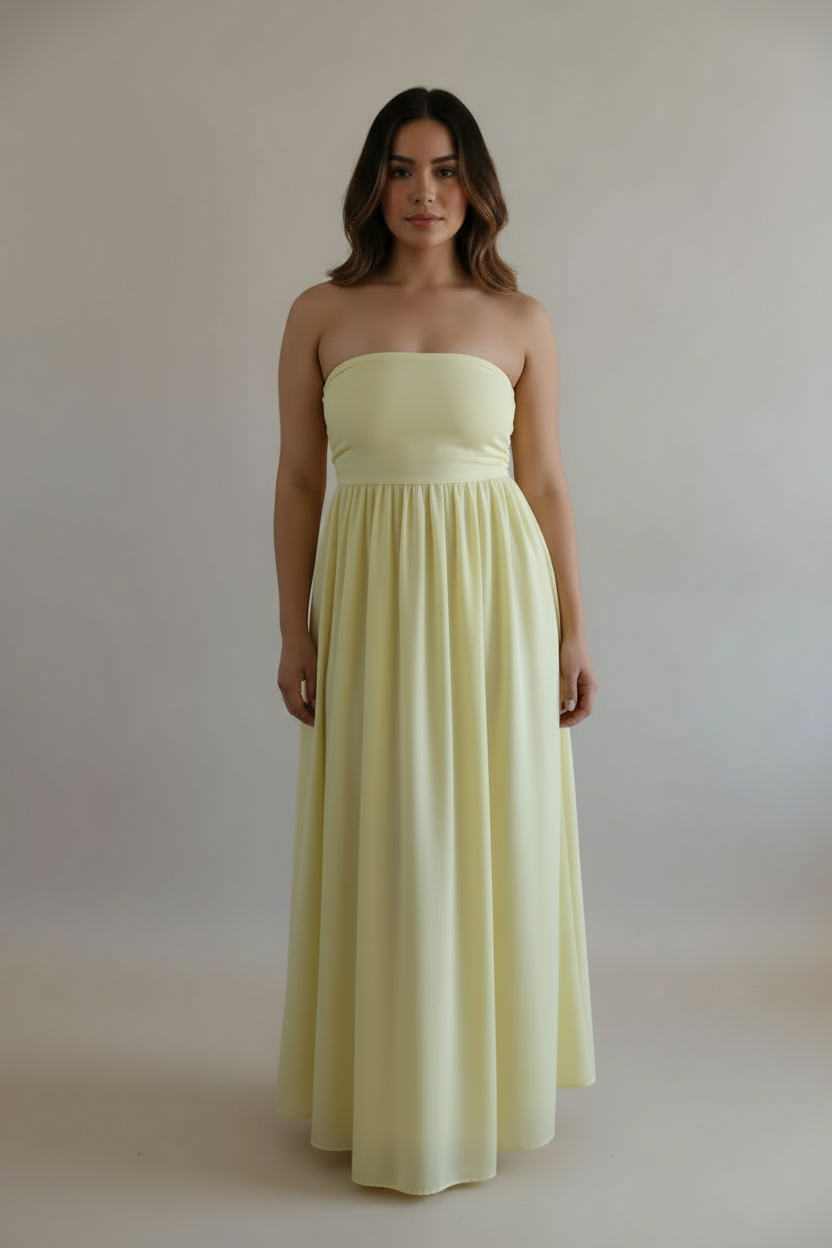 Woman wearing a strapless yellow dress against a plain background